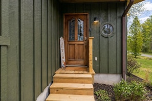A wooden front door with a glass panel, a small wooden staircase, and a sign that reads 'AUTUMN'. - Emerald Woods Hangout | Spacious, Pet Friendly, Fire Pit (Sevierville)