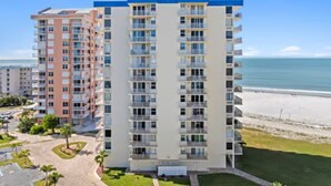 A multi-story hotel with a central courtyard, balconies, and a view of the beach. - Sky High View at EB& Tennis 1002C-NEW LISTING (Fort Myers Beach)