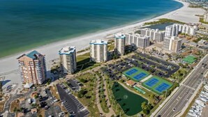 A coastal residential area with high-rise buildings, a beach, and a tennis court. - Sunset Views at EB & Tennis Club 104C (Fort Myers Beach)