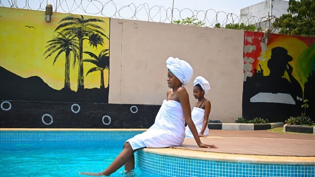 A swimming pool with tiled edges and a mural on the wall. - Hotel Viana (Viana)