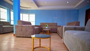 A modern lounge area with sofas and a round table. - Hotel Viana (Viana)