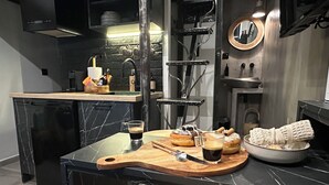 Una cocina moderna con encimera de mármol, tabla de madera para cortar y un bol de pan.
