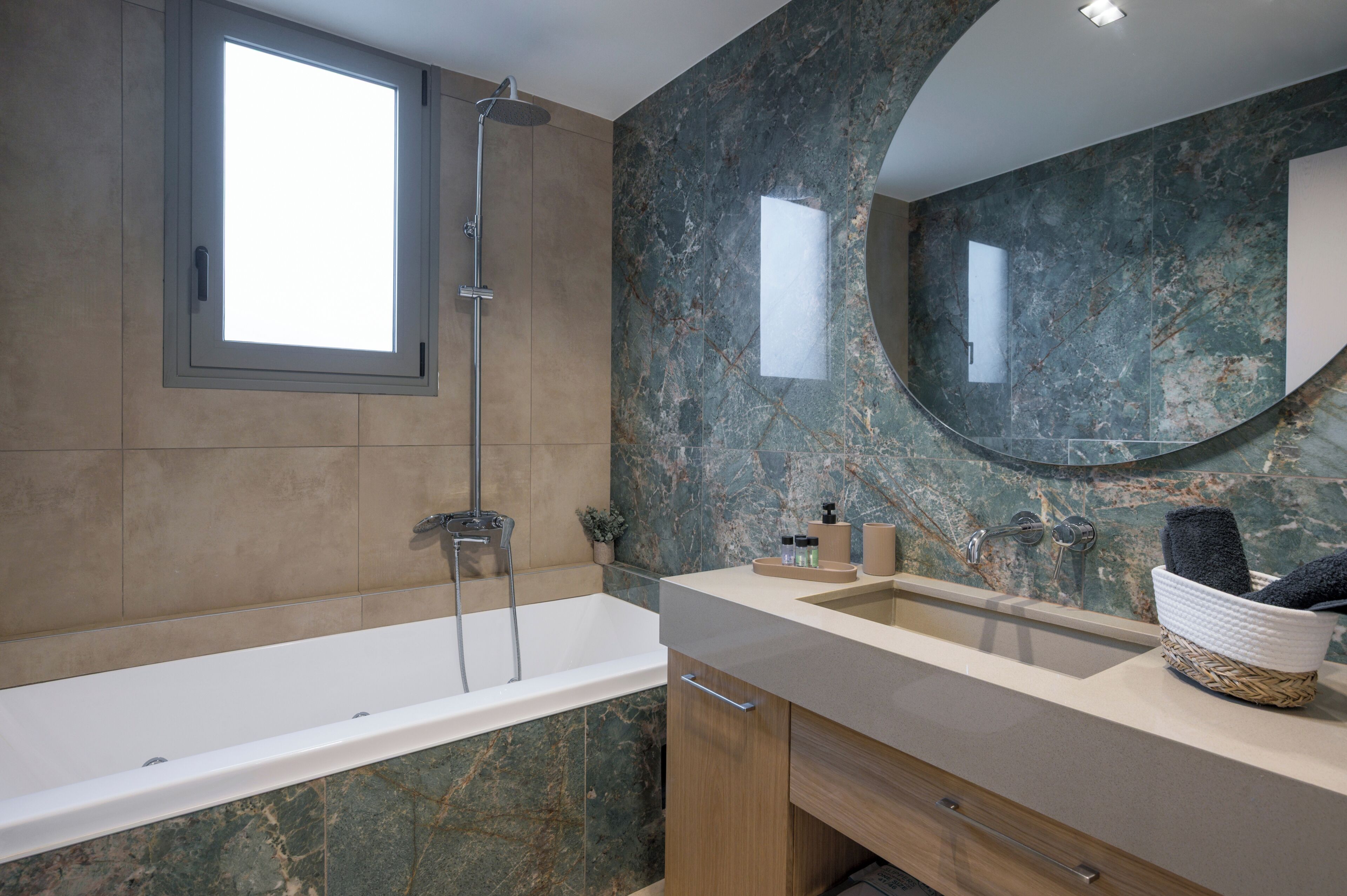 Un baño moderno con bañera, ducha, lavamanos y un espejo grande.