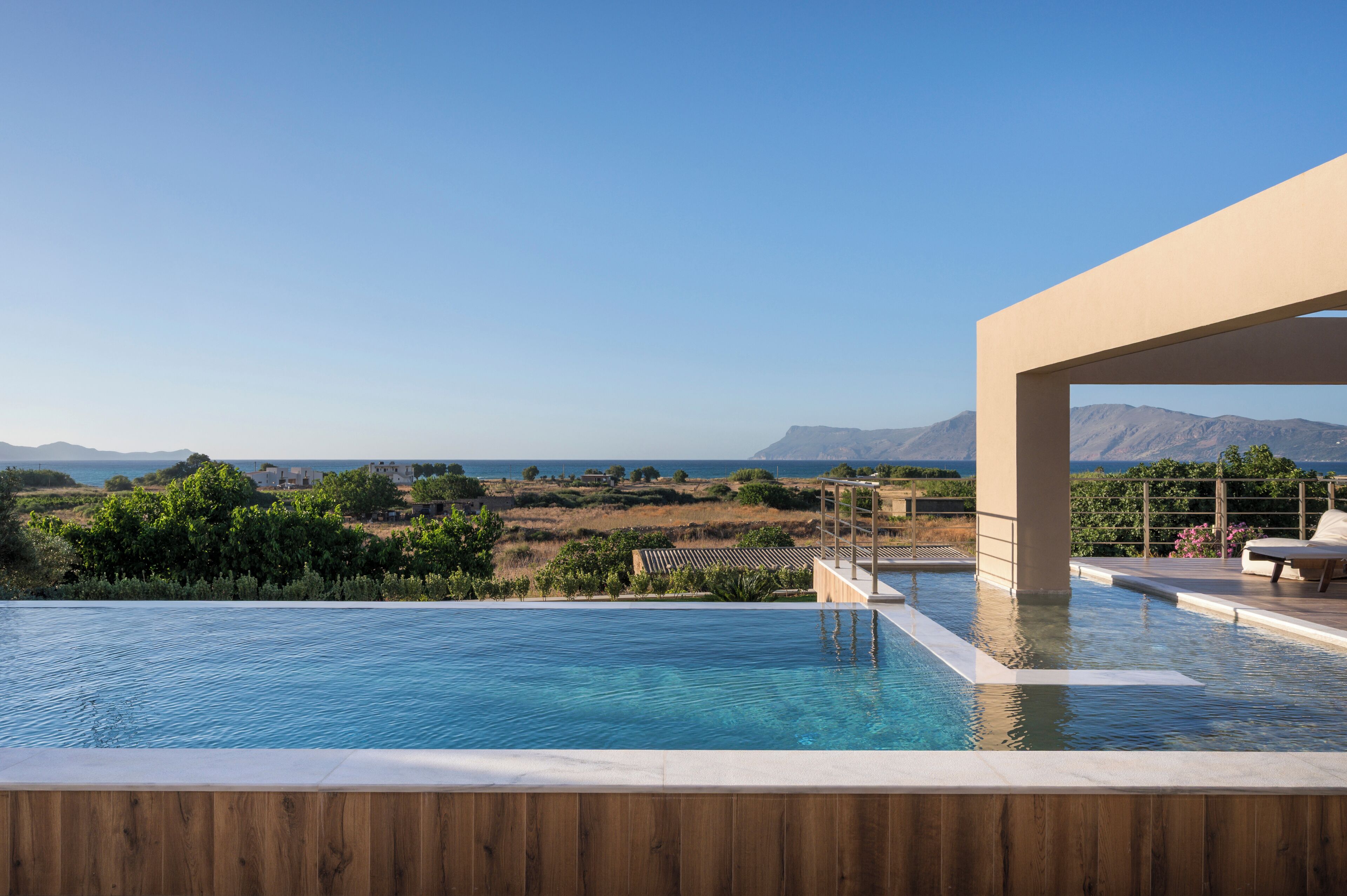 Una piscina con vistas a montañas y un cielo despejado.