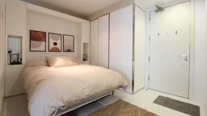 Un dormitorio con una cama, un armario y una puerta.