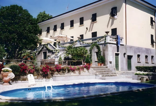A building with a pool, stairs, and a balcony.