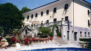 Ein Gebäude mit Schwimmbecken, Treppe und Balkon.