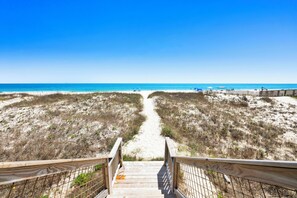 A wooden boardwalk leading to a beach with dunes and a clear blue sky. - Gulf Front Duplex | Pet Friendly | Private Hot Tub (Fort Morgan)