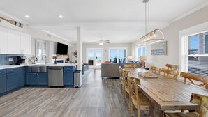 Cozinha espaçosa com mesa de jantar de madeira, eletrodomésticos embutidos e vista para o exterior.