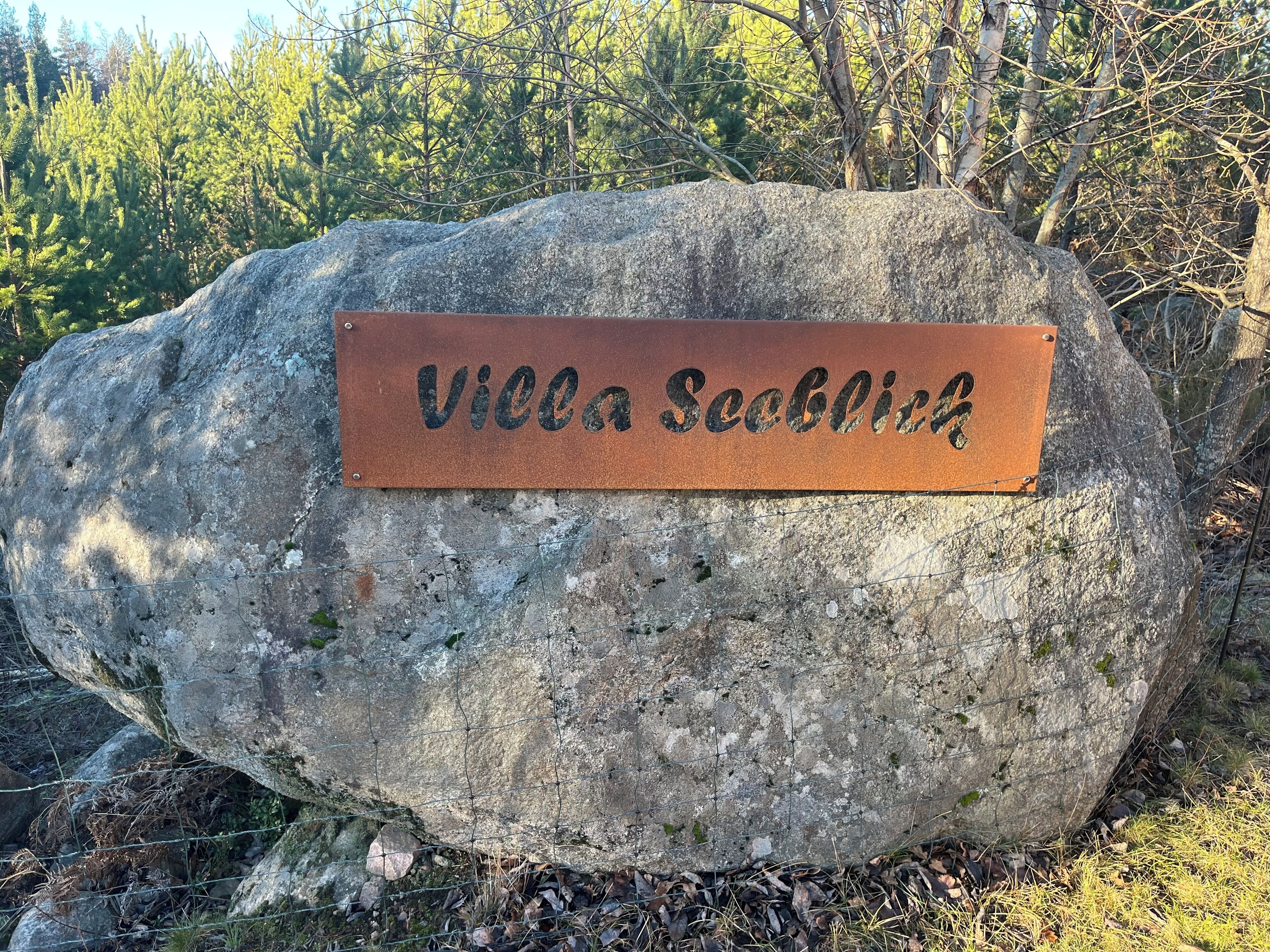 A large rock with a metal plaque that reads "Villa Seeblick".
