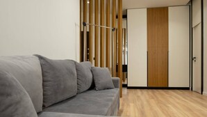 Una sala moderna con un sofá gris, listones de madera y piso de madera.