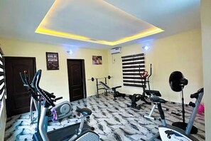 A gym with exercise equipment, a patterned floor, and a ceiling with recessed lighting.