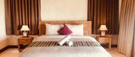 A neatly made bed with a wooden headboard, two bedside lamps, and a striped bedspread.