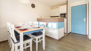 A compact kitchen with a microwave, a coffee maker, and a clock on the wall. - La Parenthèse Bleue – Sea View and Pool (Fouesnant)