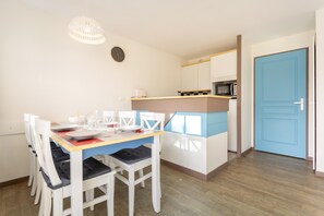 A compact kitchen with a microwave, a coffee maker, and a clock on the wall. - La Parenthèse Bleue – Sea View and Pool (Fouesnant)