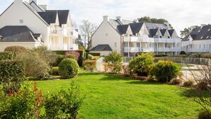 A residential area with houses featuring gabled roofs and white balconies. - La Parenthèse Bleue – Sea View and Pool (Fouesnant)