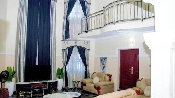 A spacious living room with a flat-screen TV, a round coffee table, and two sofas. - Exclusive Holiday Villa in Umuahia (Umuahia)