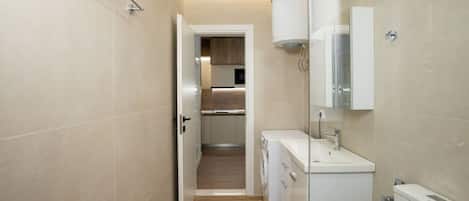 Un baño moderno con ducha, lavamanos y espejo.