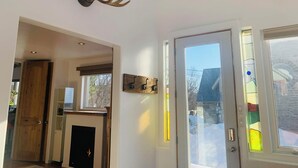Un intérieur moderne avec une porte en bois, une cheminée et une ramure de cerf accrochée au mur.
