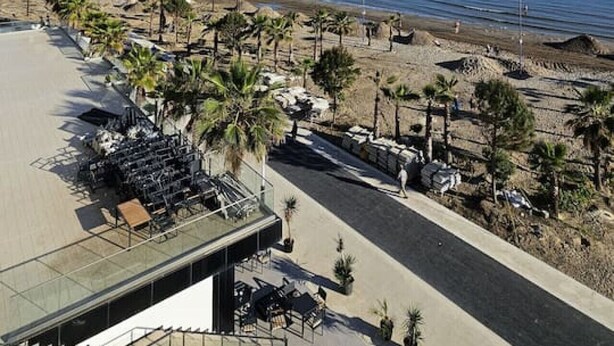 A coastal hotel with a view of the sea, a parking area, and a beach with palm trees. - Terrace View Apartment Durres (Durrës)