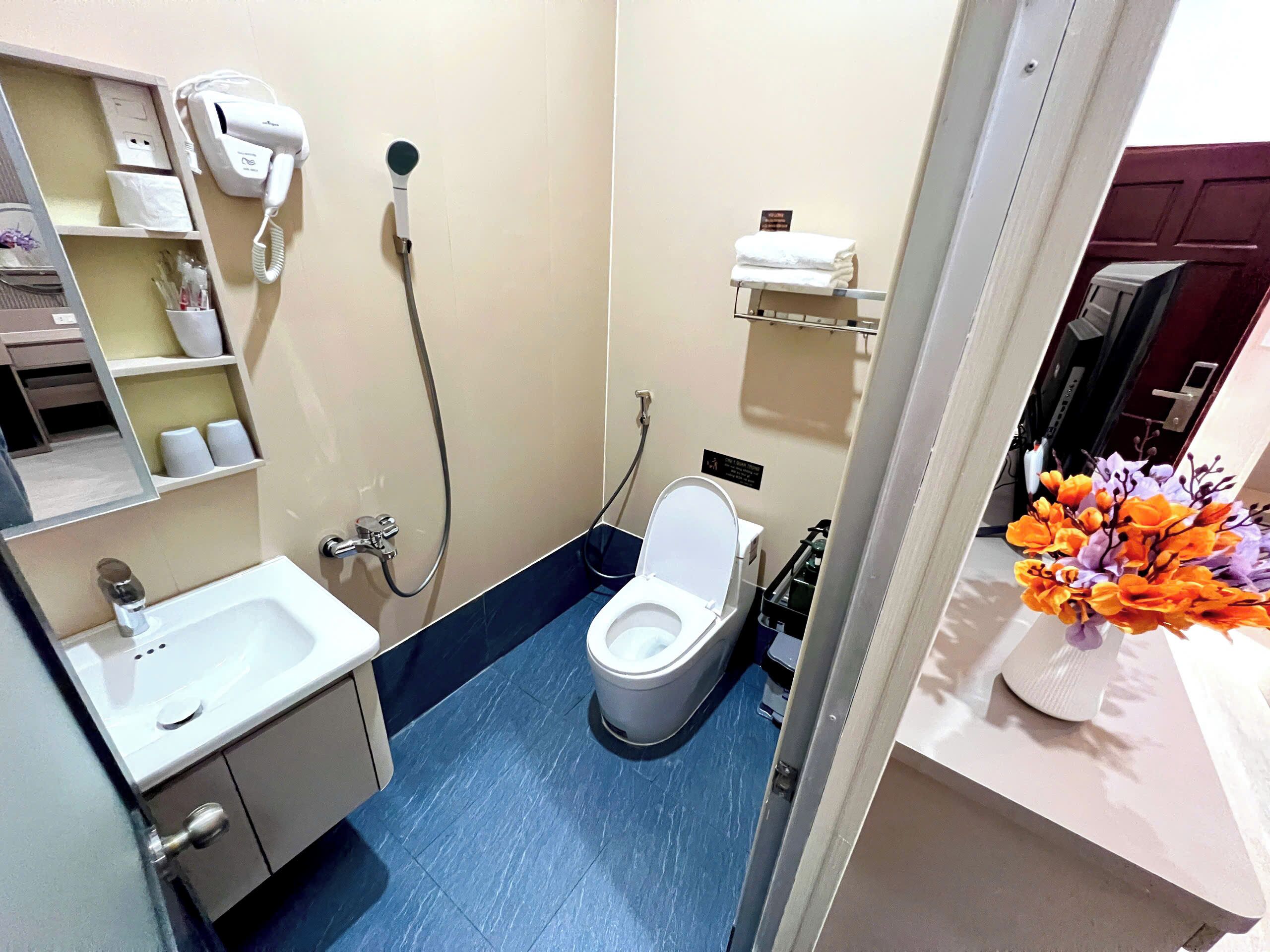 A compact bathroom with a toilet, sink, and shower.