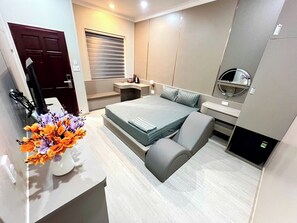 Quarto moderno com cama, mesa de cabeceira e espelho.