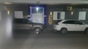 Un parking où deux voitures sont garées sur des places adjacentes.