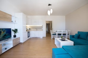 A modern apartment with a kitchen, dining area, and living room.