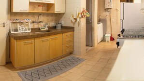 Una cucina con mobili in legno, un lavello, un fornello e un frigorifero.