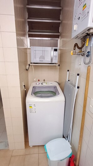 Ein kleiner Hauswirtschaftsraum mit Waschmaschine, Trockner und Mikrowelle.