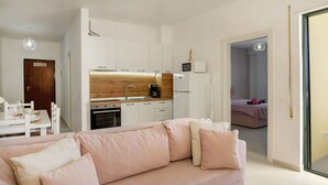 Un apartamento moderno con kitchenette, comedor y sala de estar con sofá.