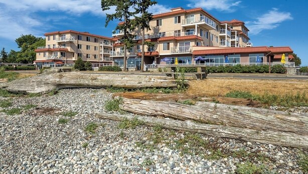 Een hotel met meerdere verdiepingen, balkons, een restaurant en uitzicht op het strand.