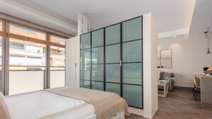 A modern bedroom with a bed, a sliding glass door, a desk, and a chair. - Bright & Functional Studio Near Bernabéu (Madrid)