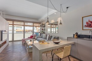 Un appartement moderne comprenant un coin repas, une cuisine et un espace de vie.
