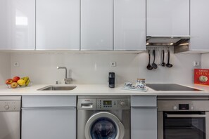 A modern kitchen with a dishwasher, washing machine, and oven. - Elegant 2-Bed Apartment in Central Madrid (Madrid)