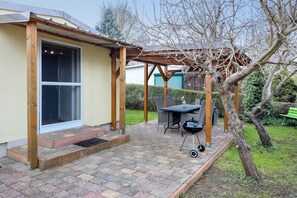 A patio with a table and grill, a covered seating area, and a pergola. - Bungalow on Lake Schwieloch for 2 Guests (Schwielochsee)