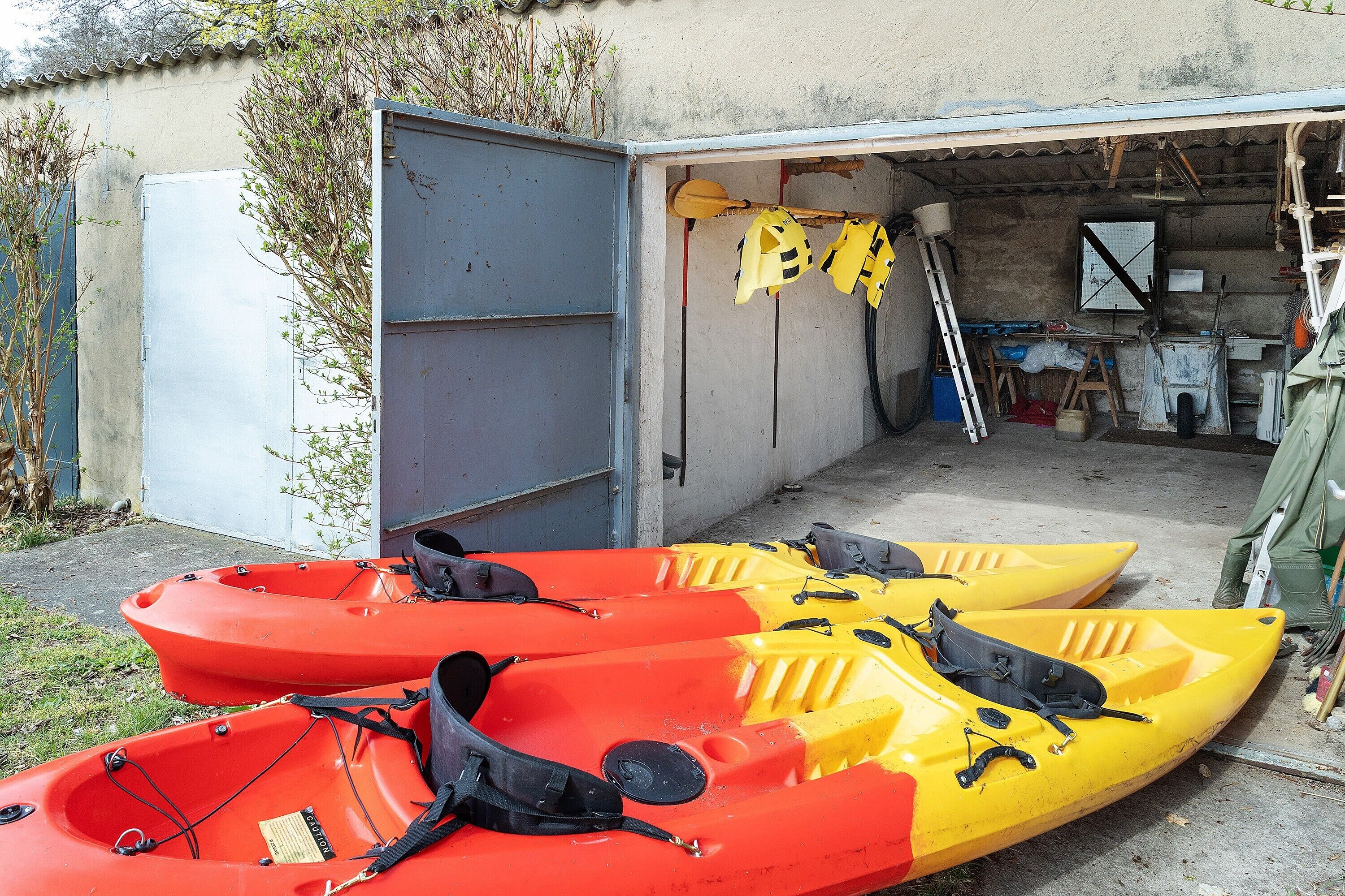 Two kayaks, a ladder, and a garage door.
