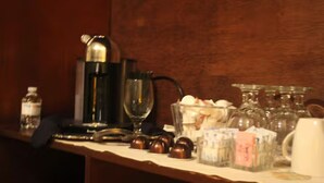 A bar area with a coffee machine, glasses, and various bottles. - Stock's Manor Bed and Breakfast #1 (Mechanicsburg)