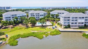 A residential building complex with multiple apartment buildings, a swimming pool, and a river. - Ocean Club N303, Soundfront Condo in Indian Beach! (Indian Beach)