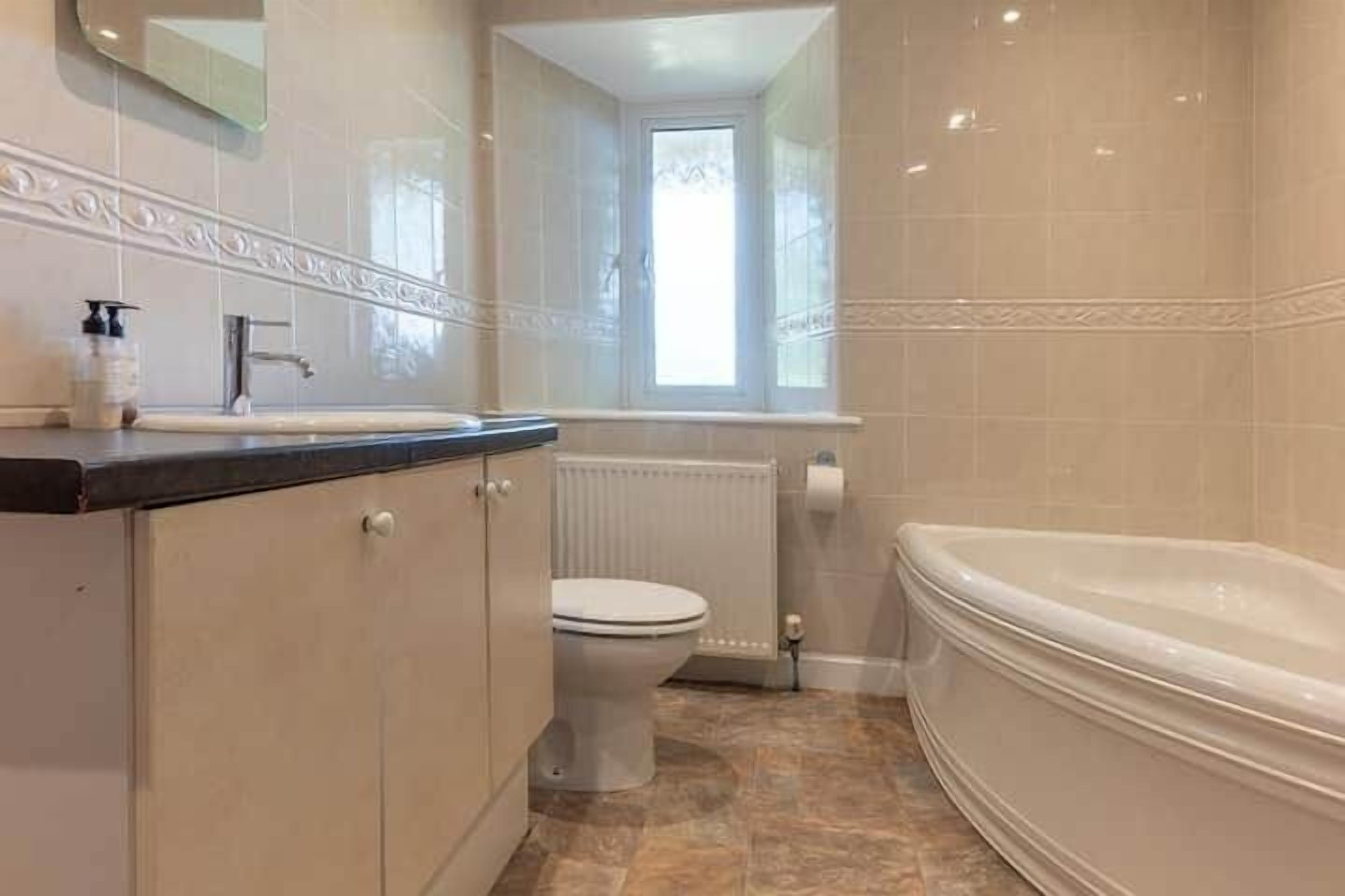 Une salle de bain avec des toilettes, un lavabo et une baignoire.