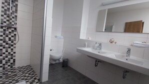 Un bagno con doccia, toilette e lavabo con specchio sopra.