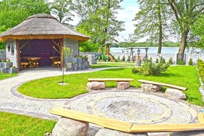 Un mirador con bancos, un hogar circular de piedra y un parque infantil con un tobogán.