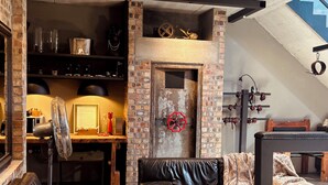 Una sala de estar moderna con chimenea de ladrillo, sofás de cuero y un ventanal grande.