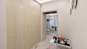 Un baño moderno con suelo de mármol, un lavabo con una alfombra azul y un espejo que refleja la habitación.