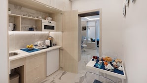 Una cocina moderna con microondas, lavabo y puertas de armario abiertas.