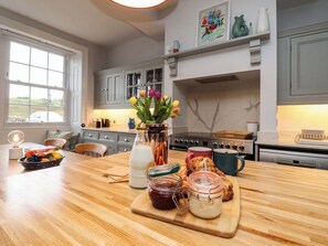 Une cuisine dotée d’un plan de travail en bois, d’une cuisinière et d’une fenêtre donnant sur l’extérieur.