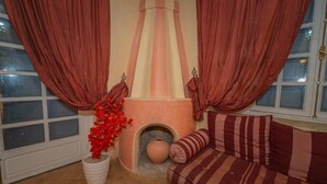 A cozy room with a fireplace, a sofa, and curtains. - Mumtaz Dar - Suite Deluxe 3 (Ouahat Sidi Brahim)