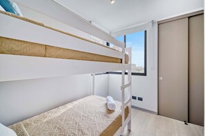 Una cama litera con un colchón estampado y una toalla enrollada en la parte inferior.