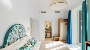 Une chambre à coucher avec un lit, une table de chevet, une armoire et une salle de bain visible à travers une porte ouverte.