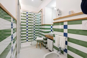 Une salle de bain avec une douche, un lavabo et des toilettes.